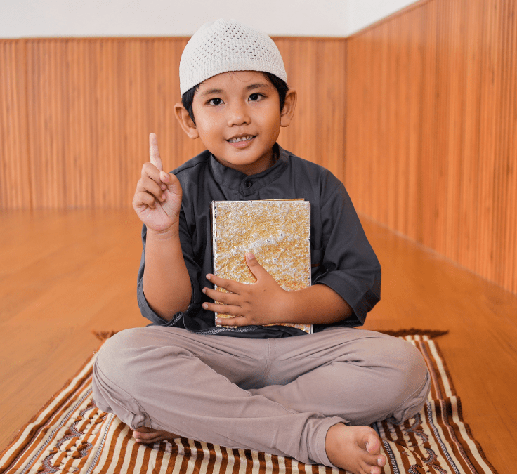 Niño musulmán levantando el dedo índice representando la Shahada, declaración de fe en el Islam