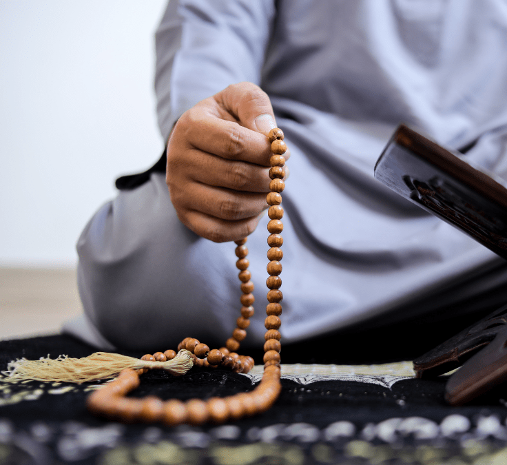 Mano sosteniendo un tasbih mientras recita el Tahlīl