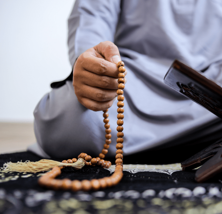 Mano sosteniendo un tasbih mientras recita el Tahlīl