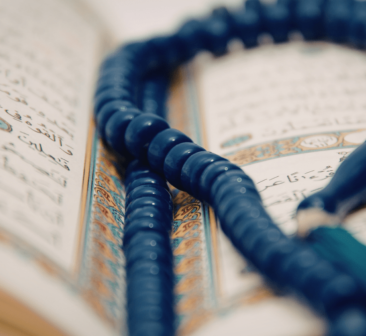Tasbih colocado dentro de un Qurán abierto representando el dhikr