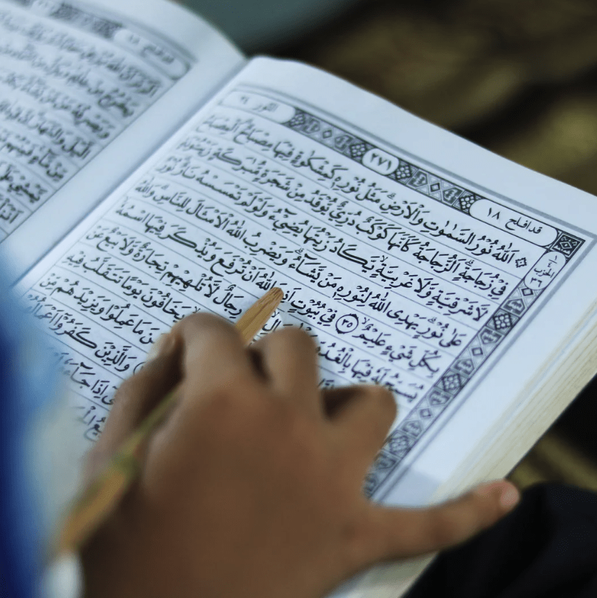 Musulmán leyendo el Noble Qurán abierto