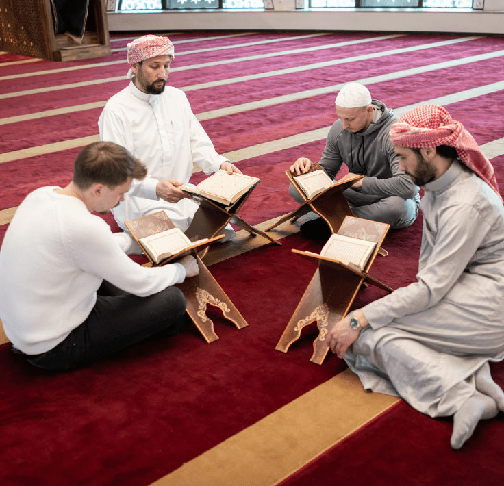 Hombre pronunciando la Shahada junto a tres musulmanes durante su conversión al Islam
