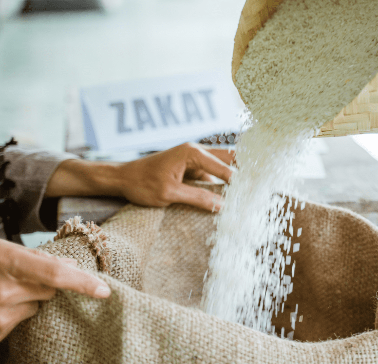 Manos entregando arroz como donación representando el Zakat en el Islam